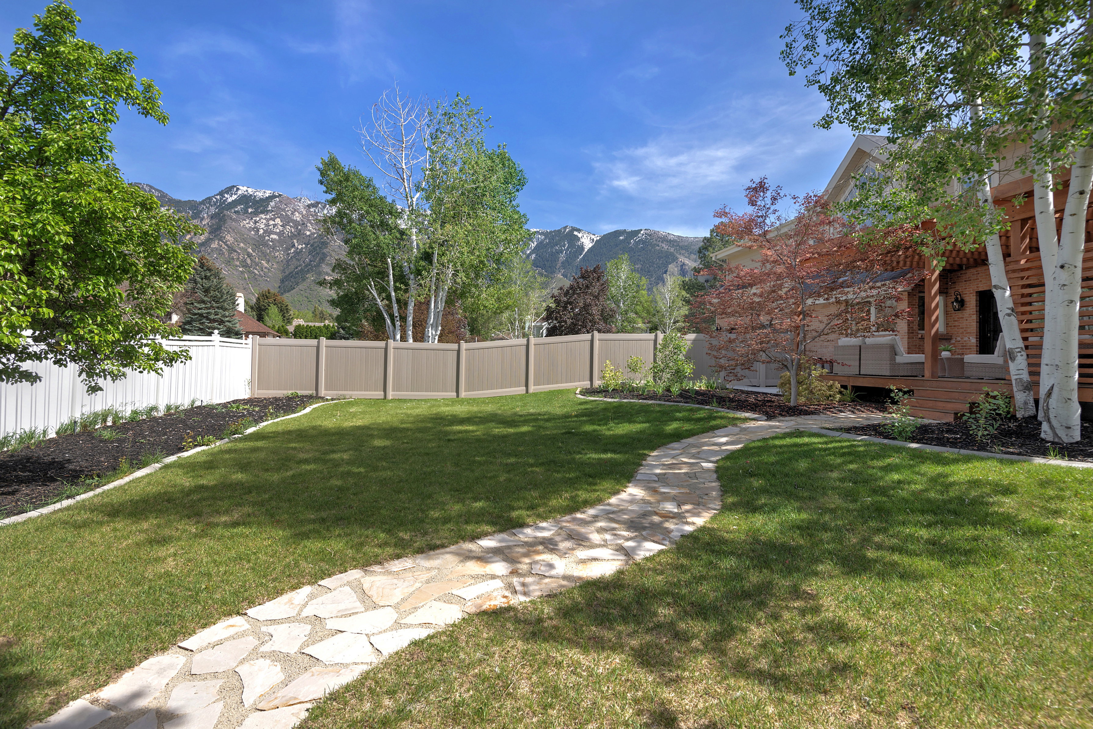 Fenced backyard featuring a deck with mountain view