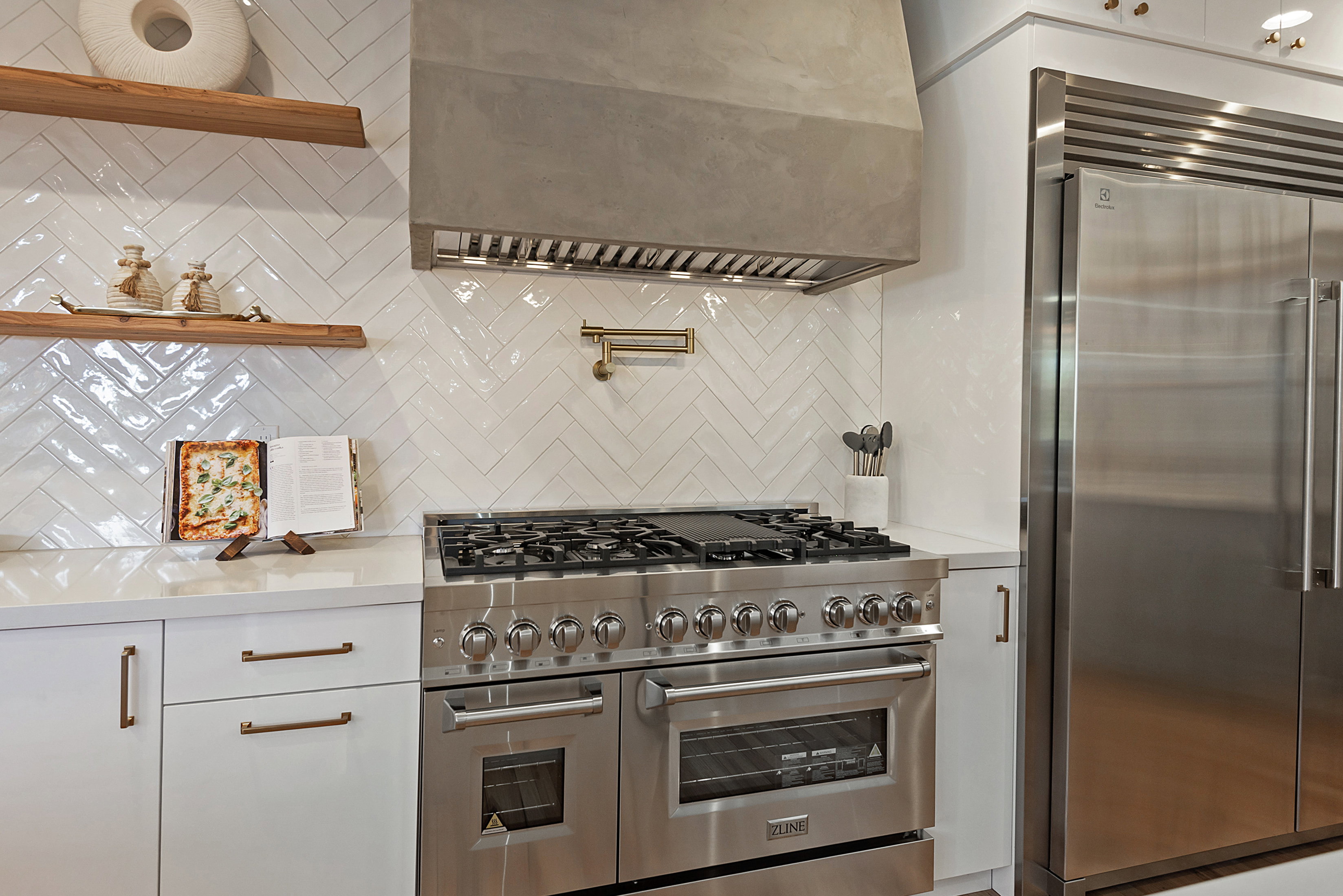 Kitchen featuring high end appliances and full wall tile.