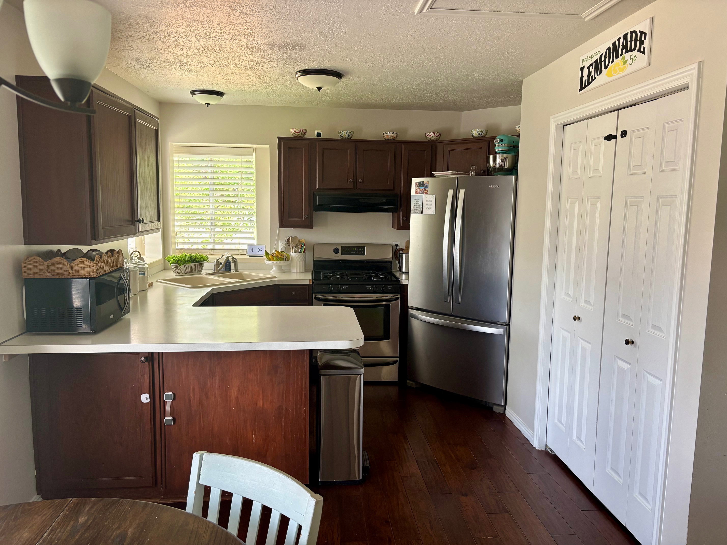 Kitchen featuring dark wood cabinetry, light-toned countertops, and wood-finish flooring