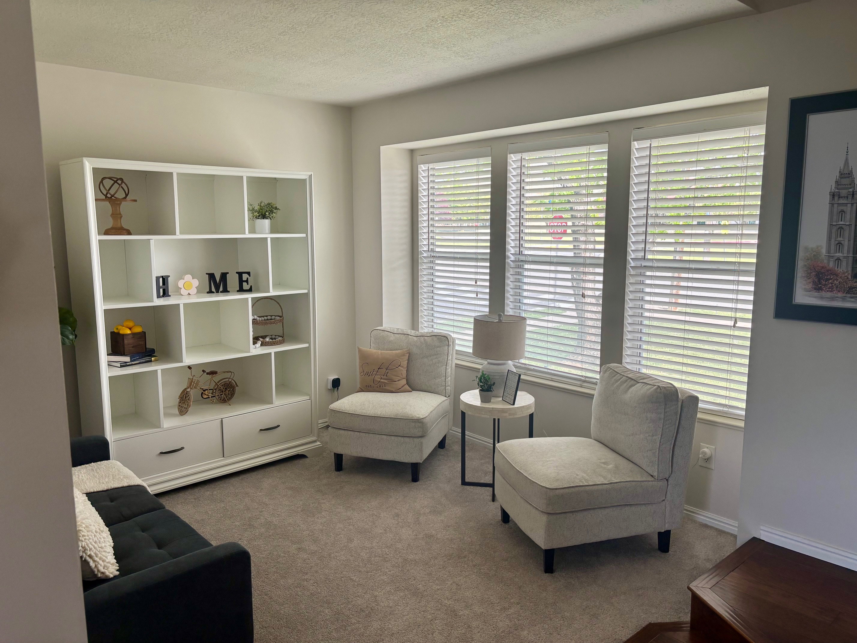 Spacious room featuring a large window, neutral wall paint, and carpeted flooring