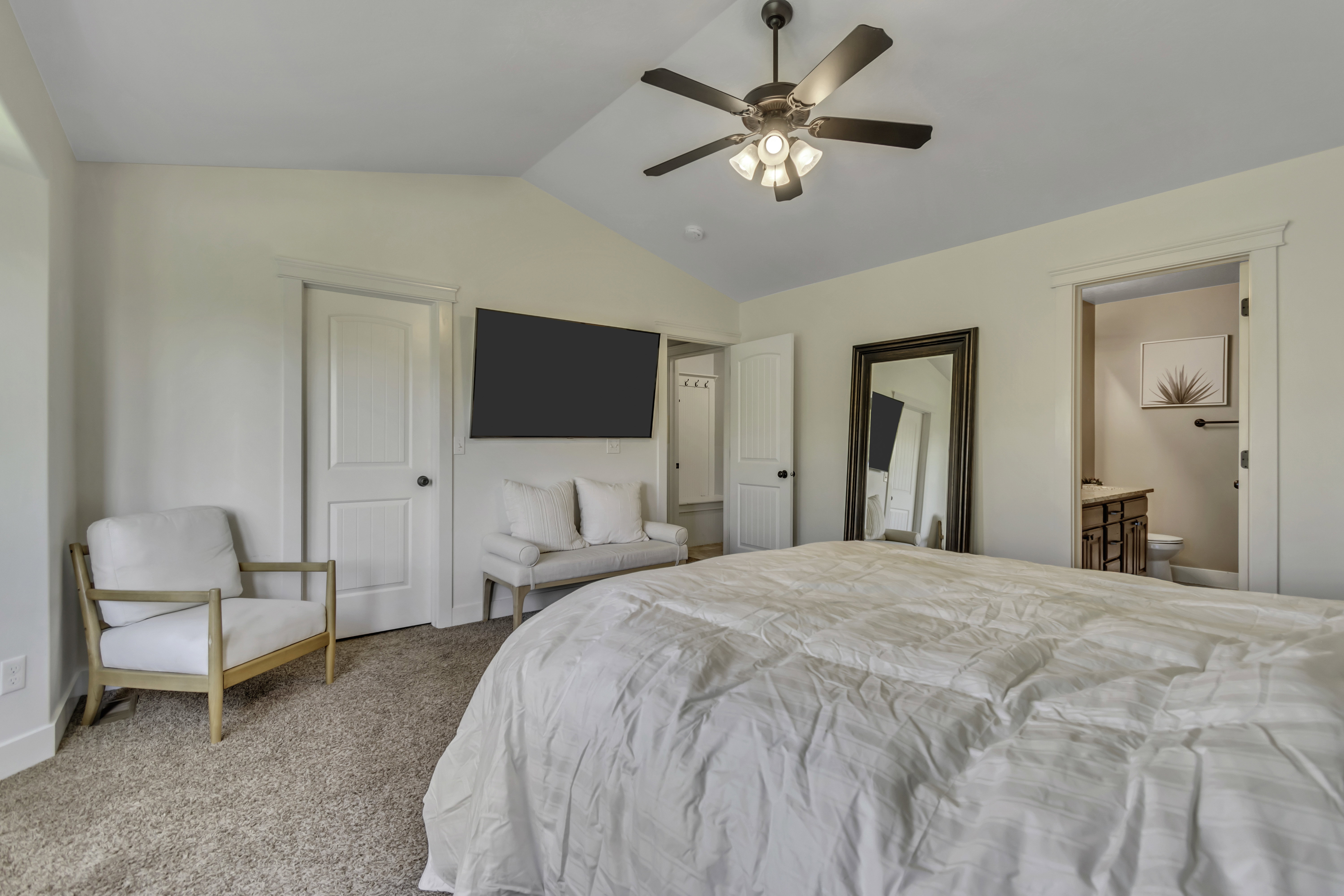 Bedroom with carpet flooring, ensuite bathroom, and a ceiling fan
