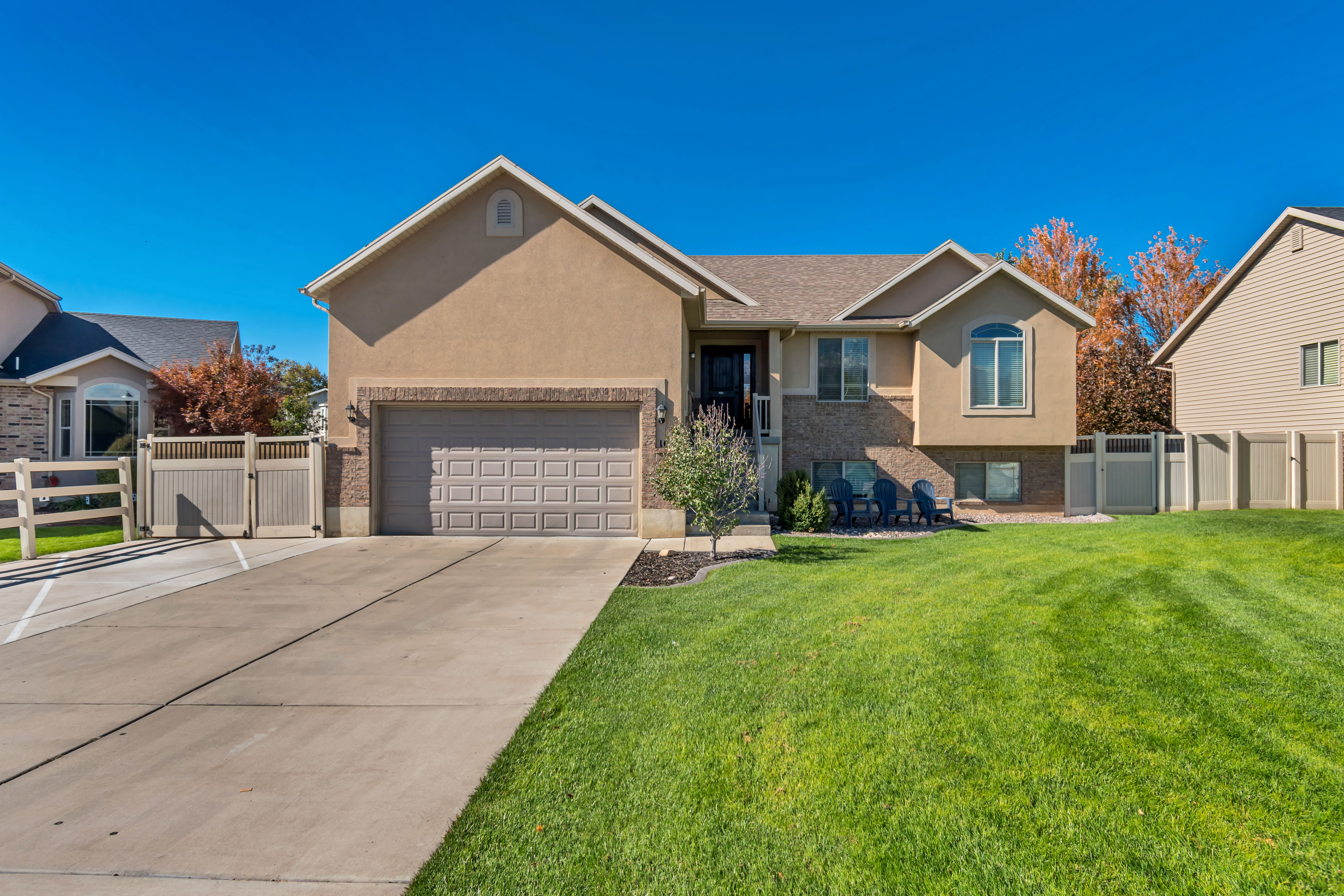 Single story home with a gate, stucco siding, concrete driveway, and brick siding
