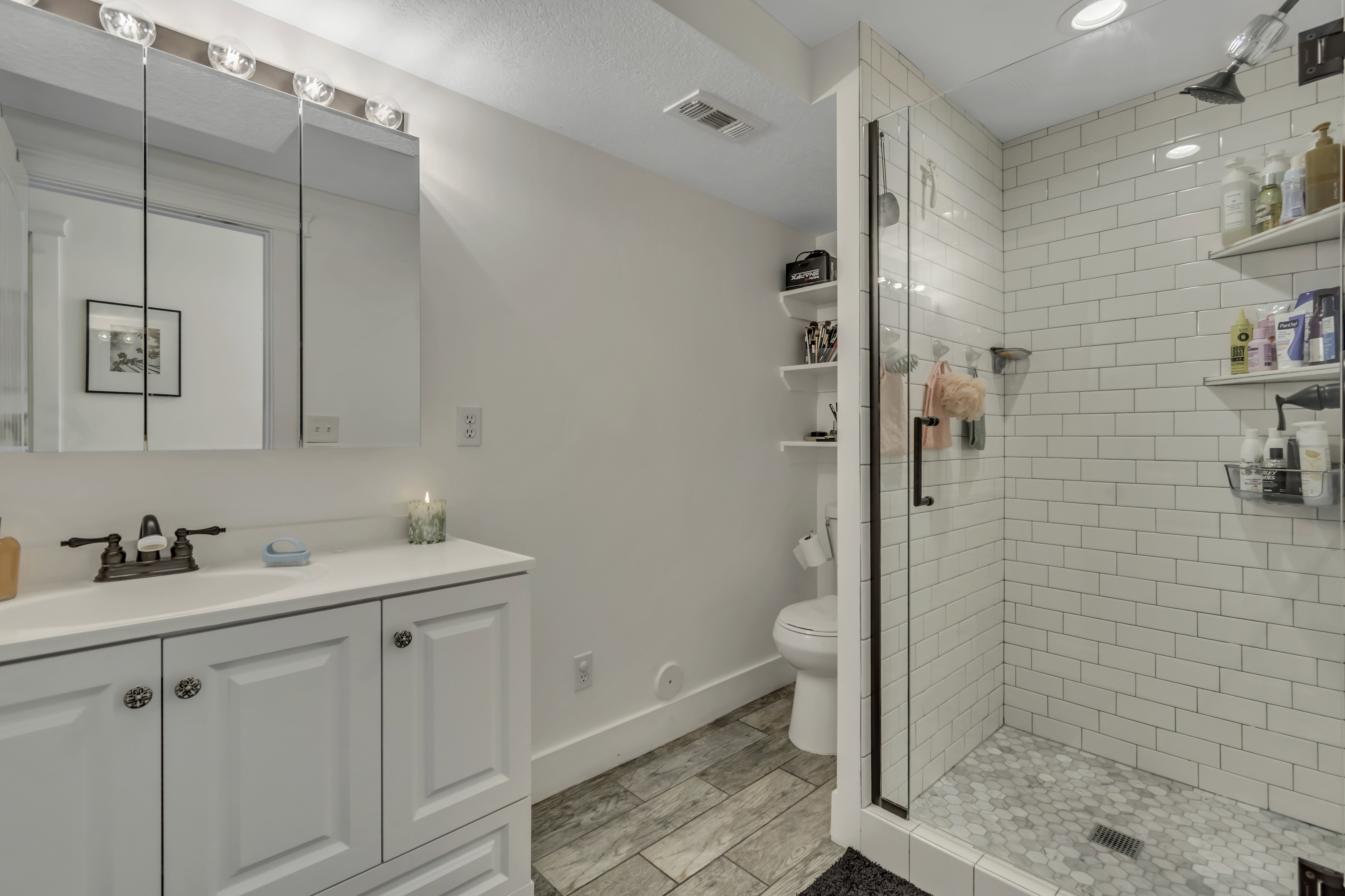 Full bath with vanity, a shower stall, and wood tiled floors