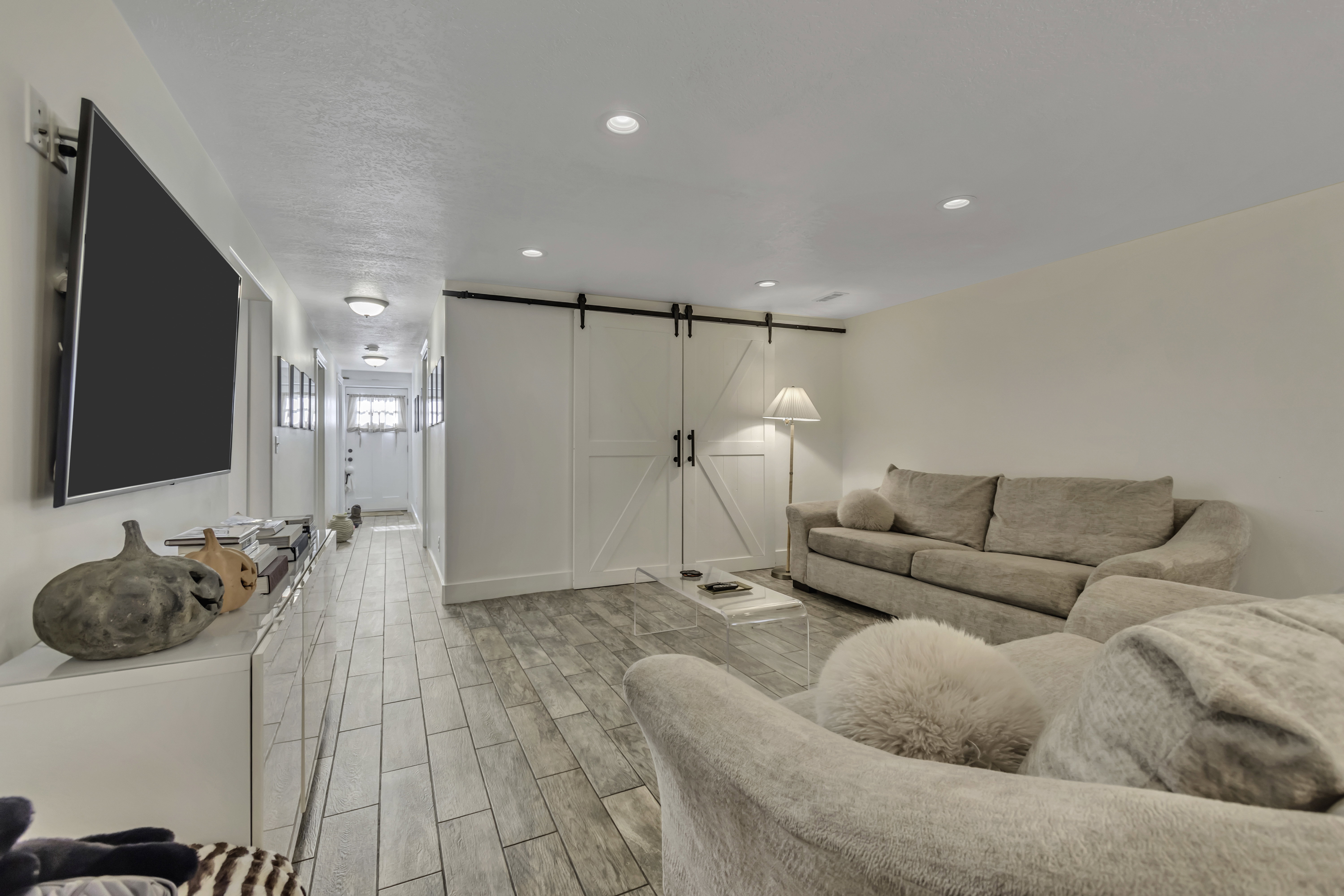 Living area with a barn door, wood finish floors, and recessed lighting