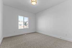 Bright room featuring a large window, neutral carpeting, white baseboards, and a contemporary ceiling fixture