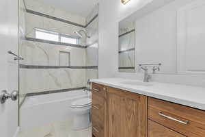 Bathroom featuring a wood-finish vanity with a white countertop, an undermount sink, and a framed mirror