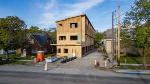 Multi-level building under construction featuring exterior sheathing and visible framing