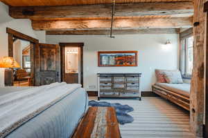 Exposed timber beams and wood-plank ceiling create a rustic aesthetic