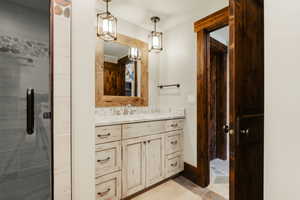 Whitewashed vanity with a light-toned countertop and dual pendant lighting fixtures