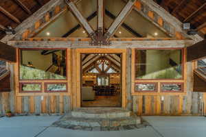 Rustic-inspired entry featuring stacked stone steps, a timber-framed porch, and a wood-paneled exterior