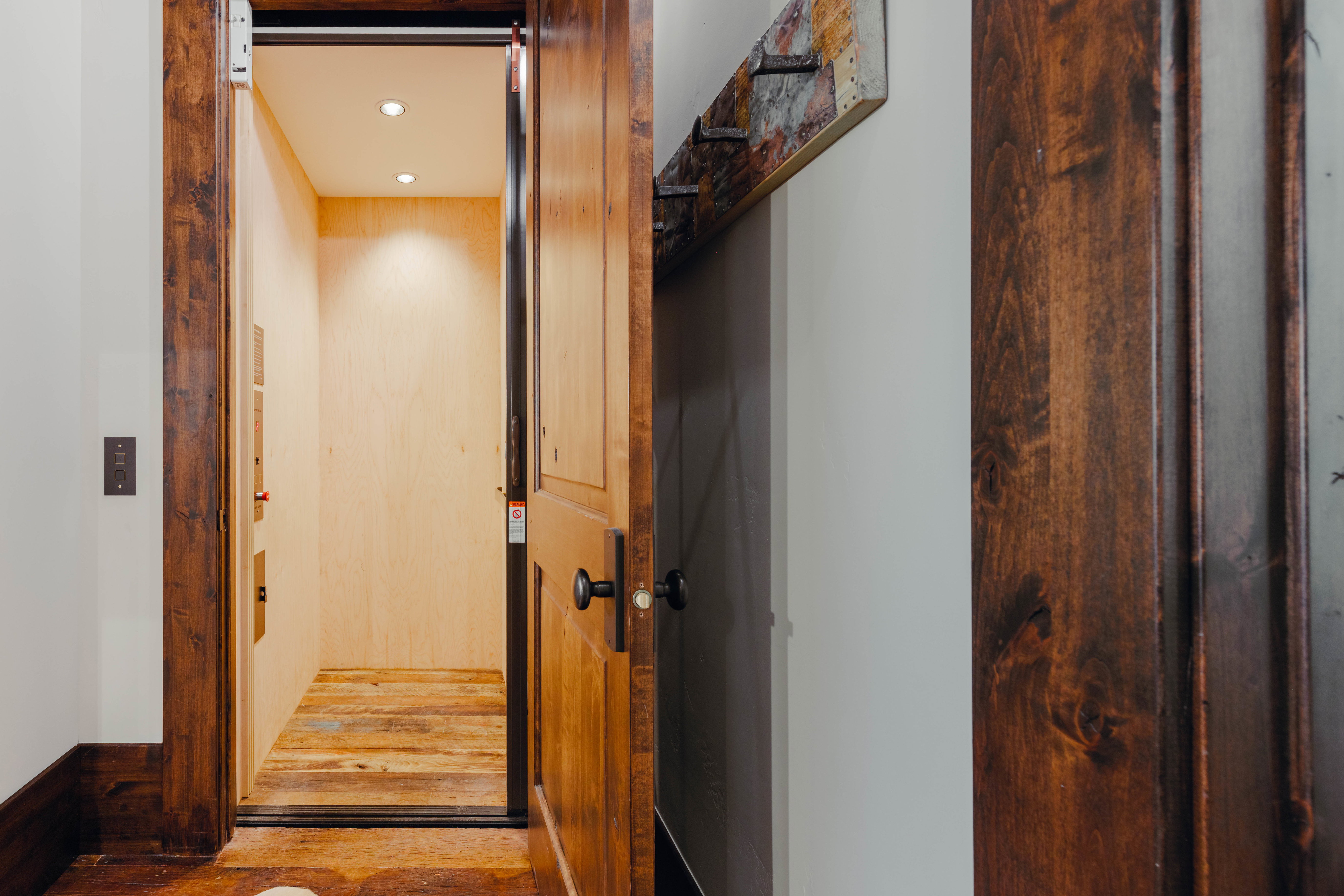 Interior elevator featuring light wood-finish walls and reclaimed wood-finish flooring