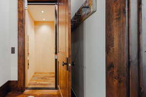 Interior elevator featuring light wood-finish walls and reclaimed wood-finish flooring
