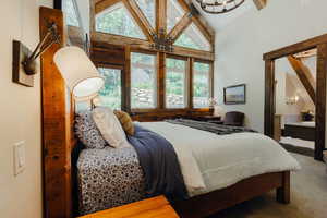 Vaulted ceiling with exposed wood beams and chandelier