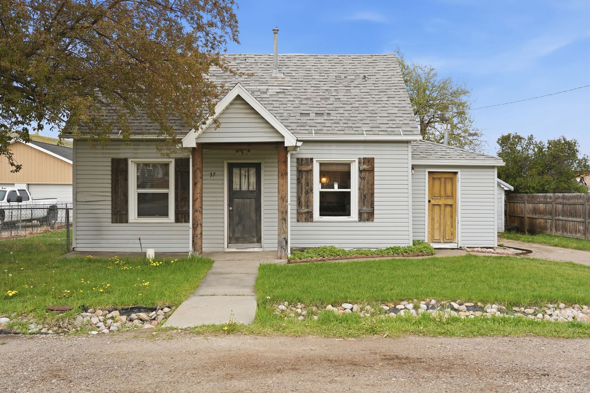 Traditional single-story residence featuring light gray siding and a pitched roof