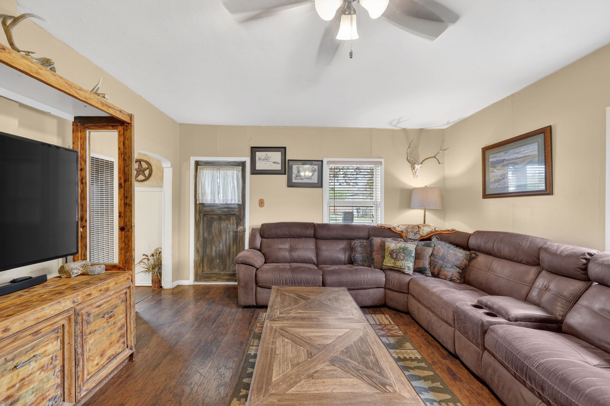 Living area featuring wood-finish flooring, a ceiling fan, and painted walls