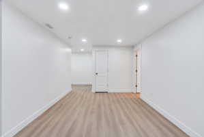 Open concept room featuring recessed lighting, wood-finish flooring, white walls, and bright white trim