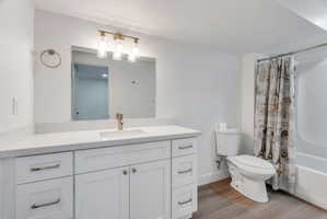 Bathroom featuring a spacious white vanity with a light speckled countertop, undermount sink, and gold-finish faucet