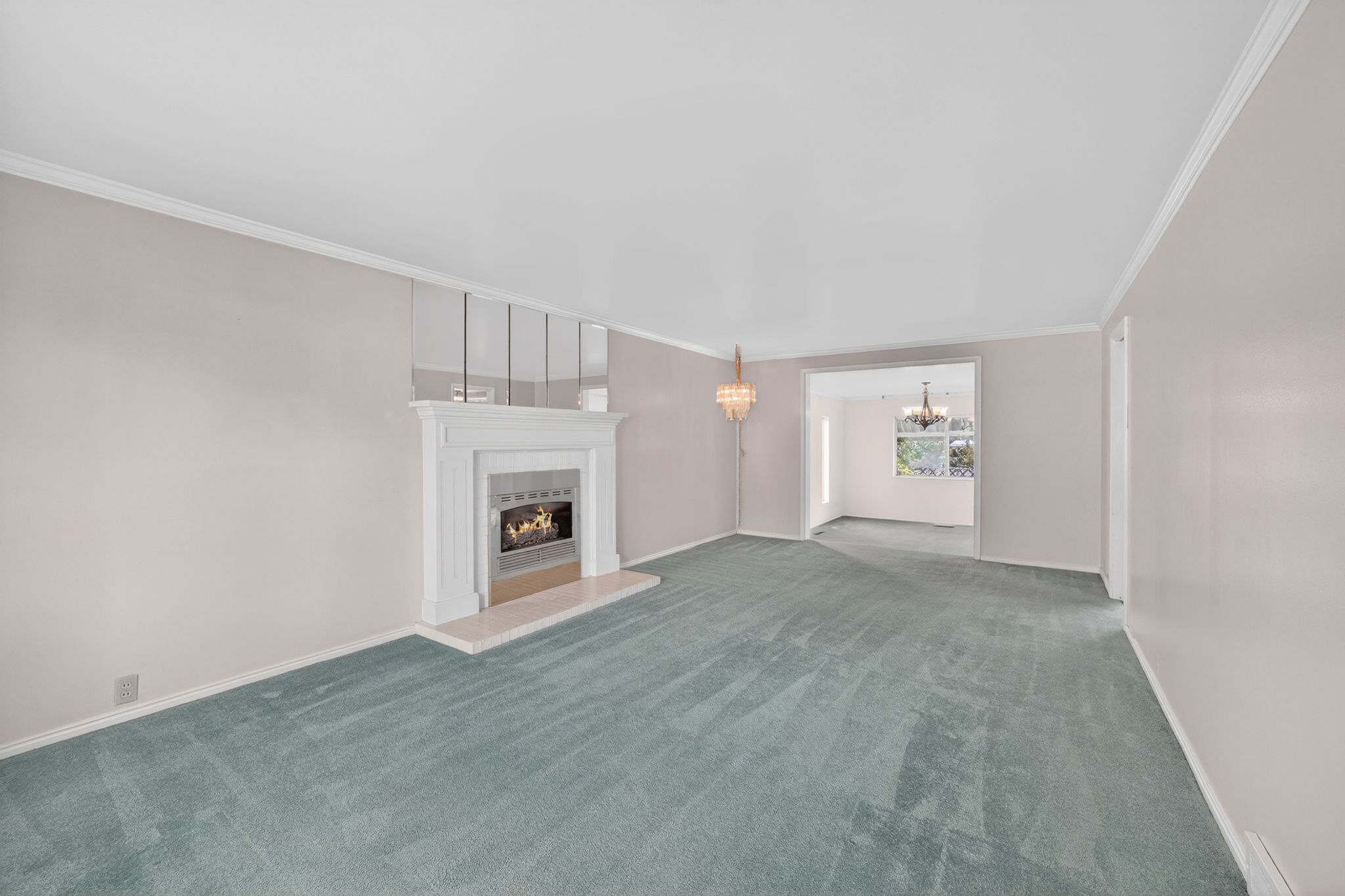 Living room featuring a classic white fireplace with a tiled hearth, framed by mirrored wall accents