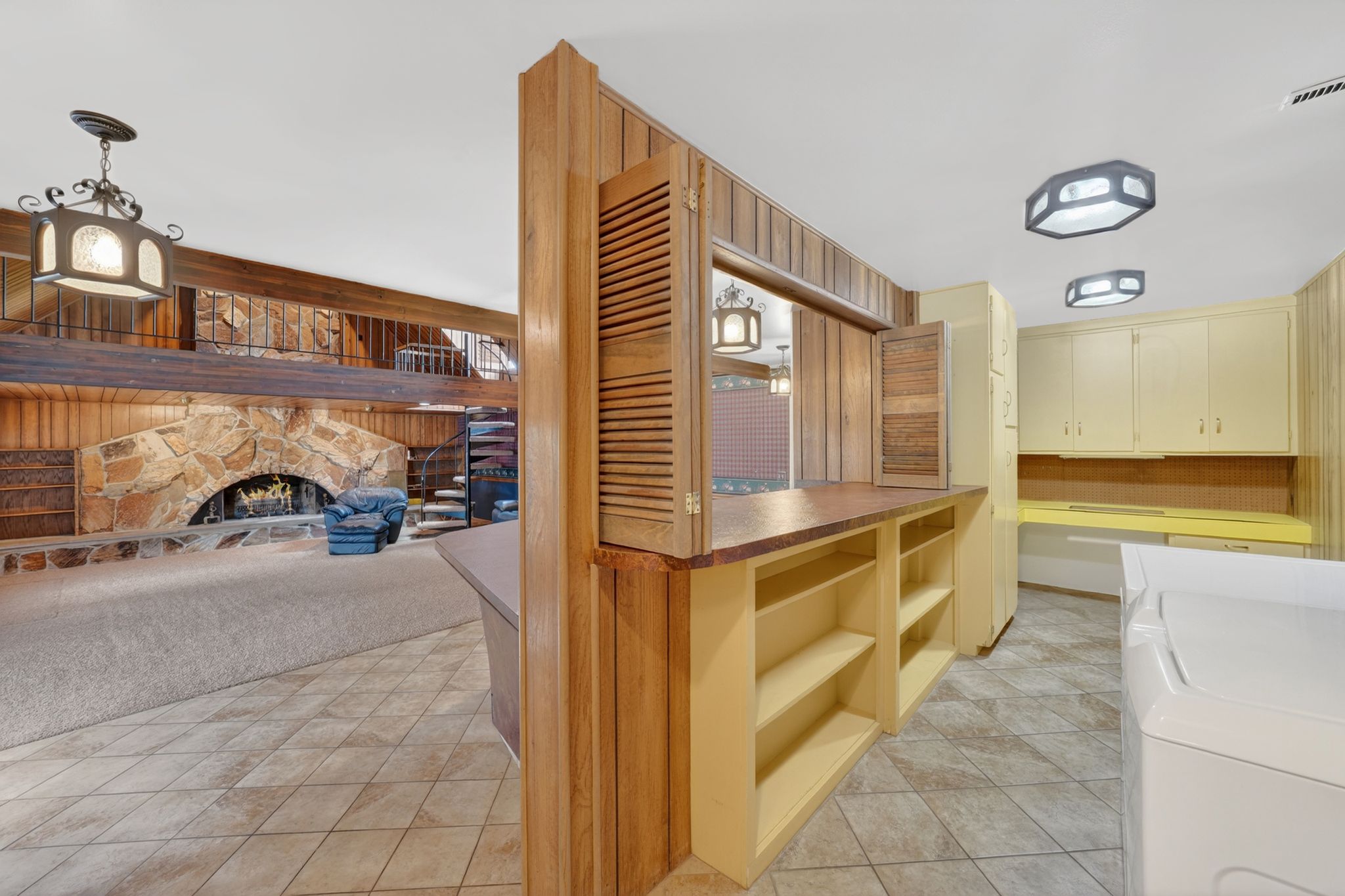 Versatile interior space featuring tile flooring and wood-paneled walls