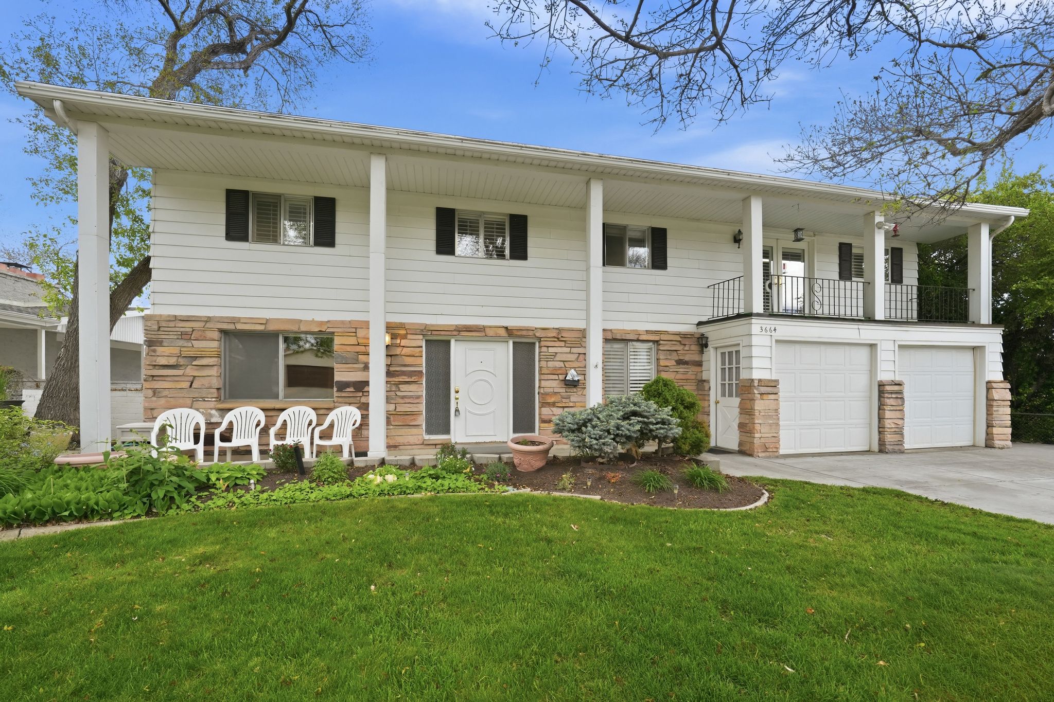 Two-story exterior with white siding and stone veneer accents