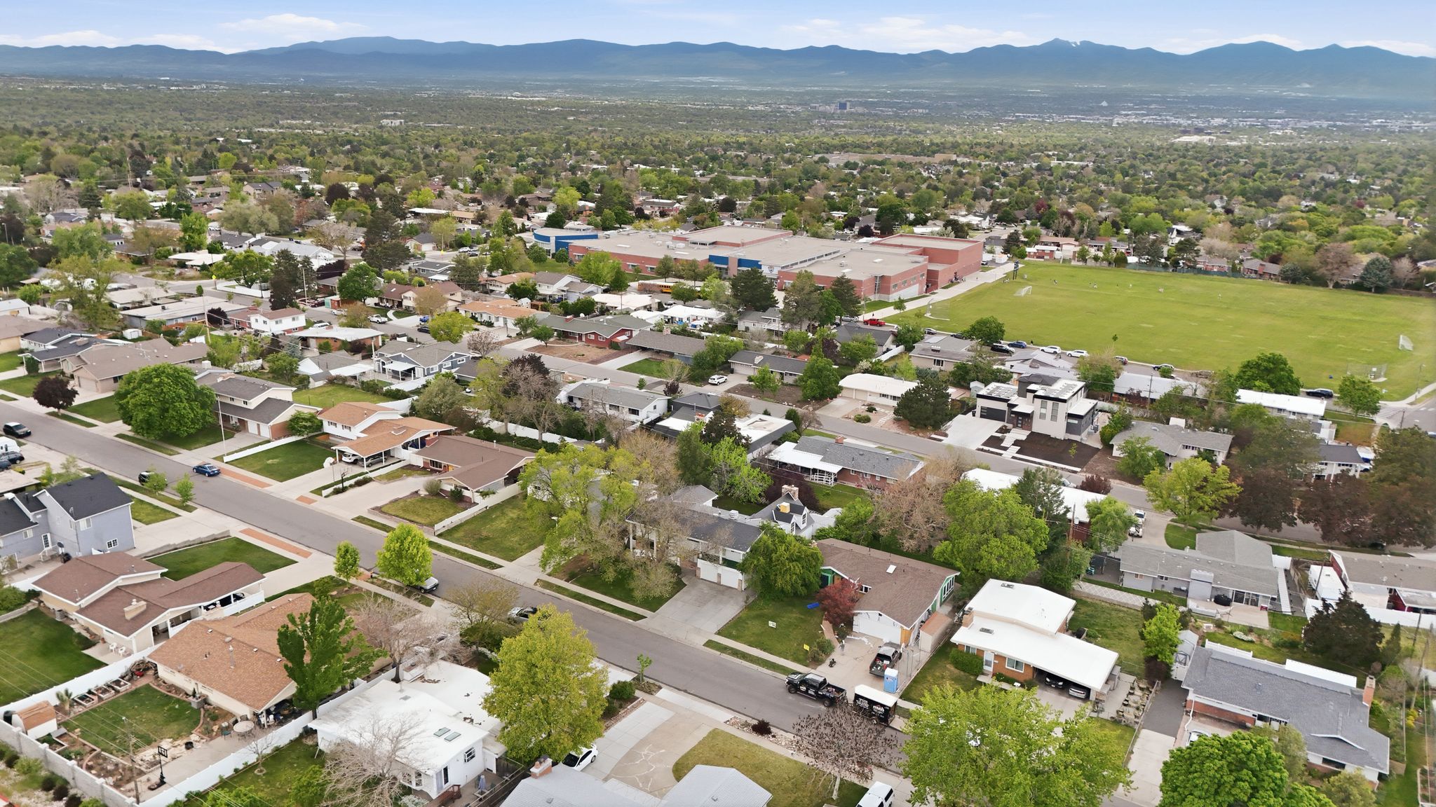 Aerial perspective showcasing a residential neighborhood with tree-lined streets and established homes