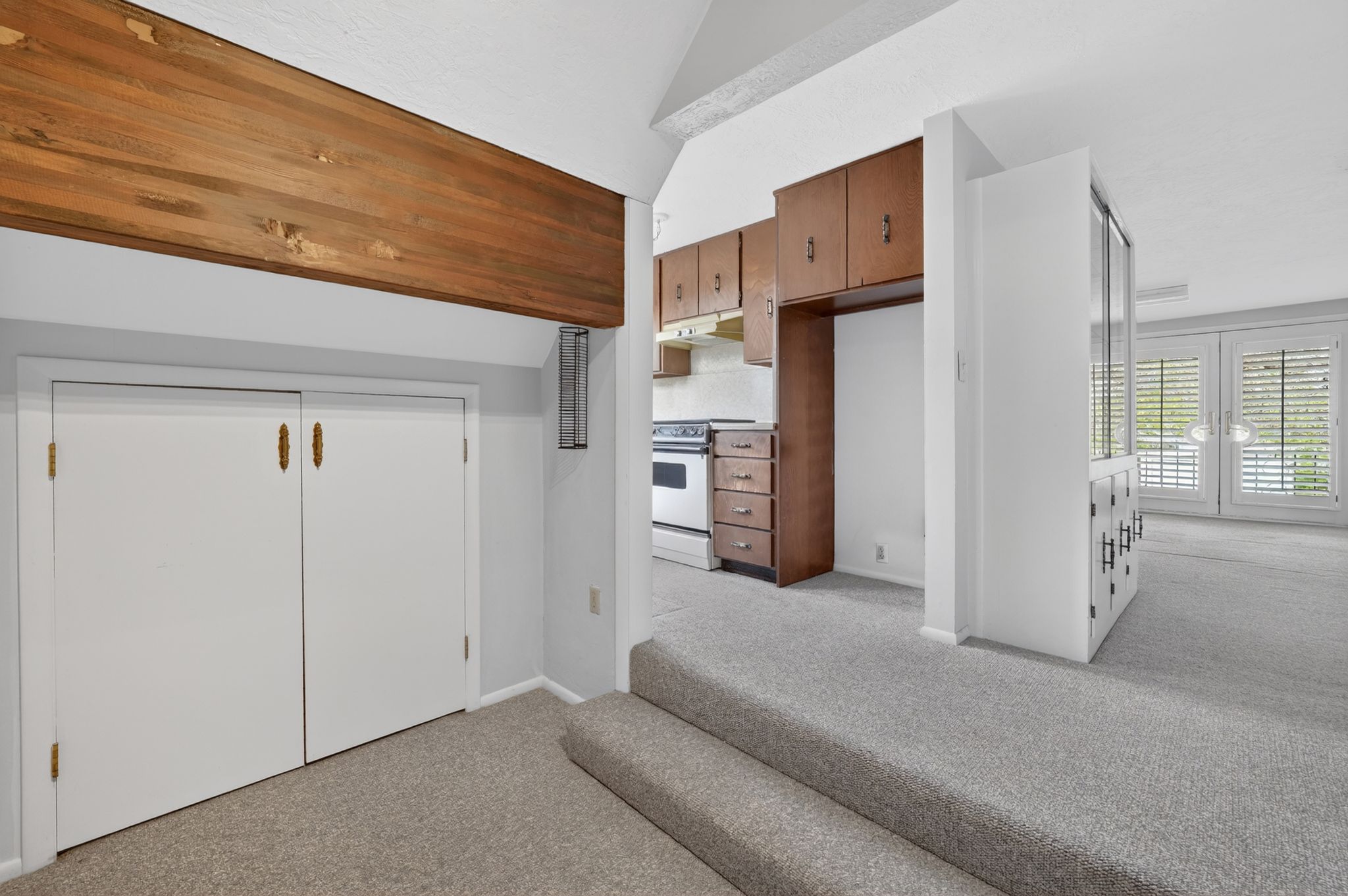 Vaulted ceiling featuring a prominent exposed wood beam