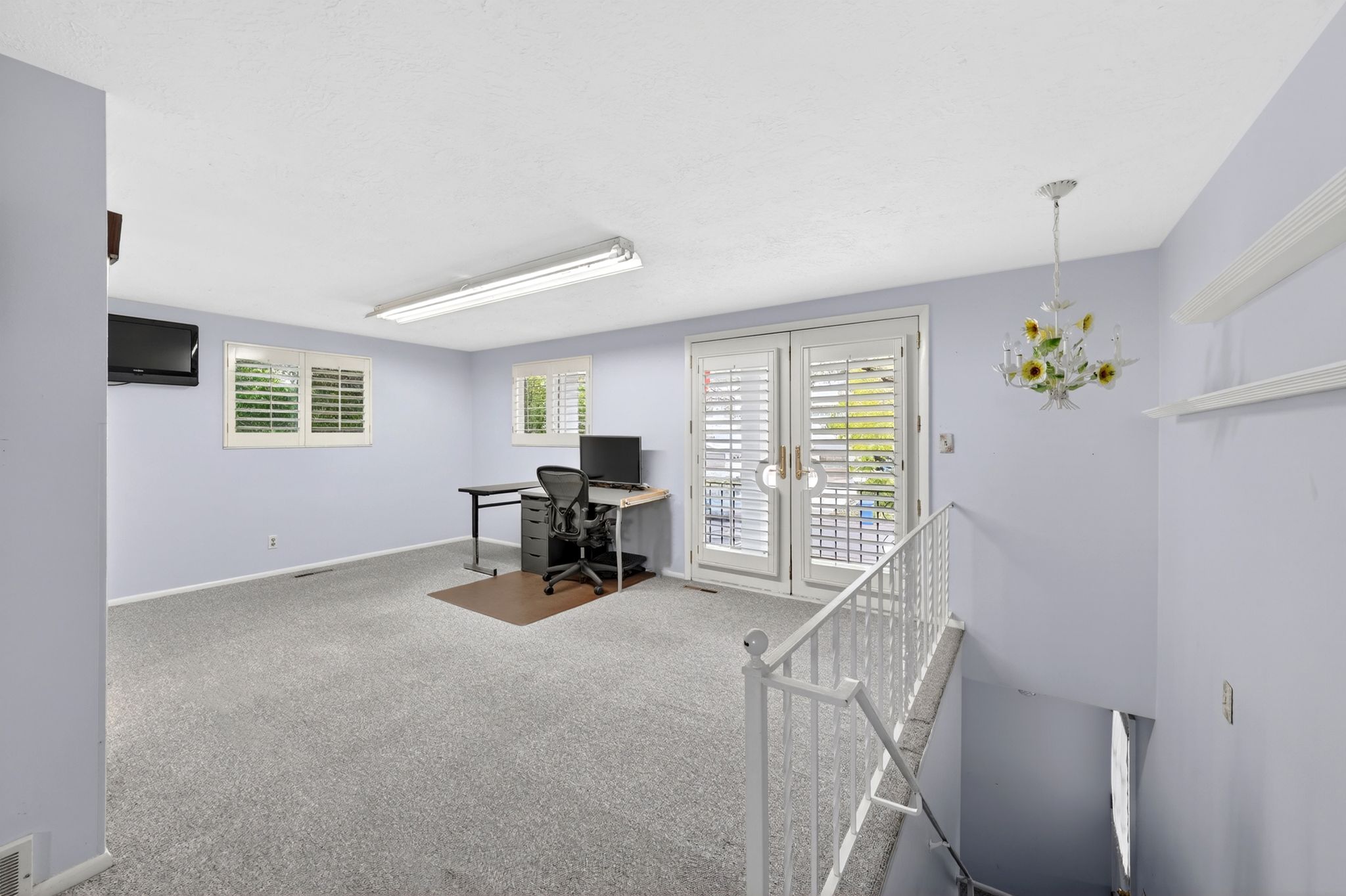Carpeted room with French doors and plantation shutters