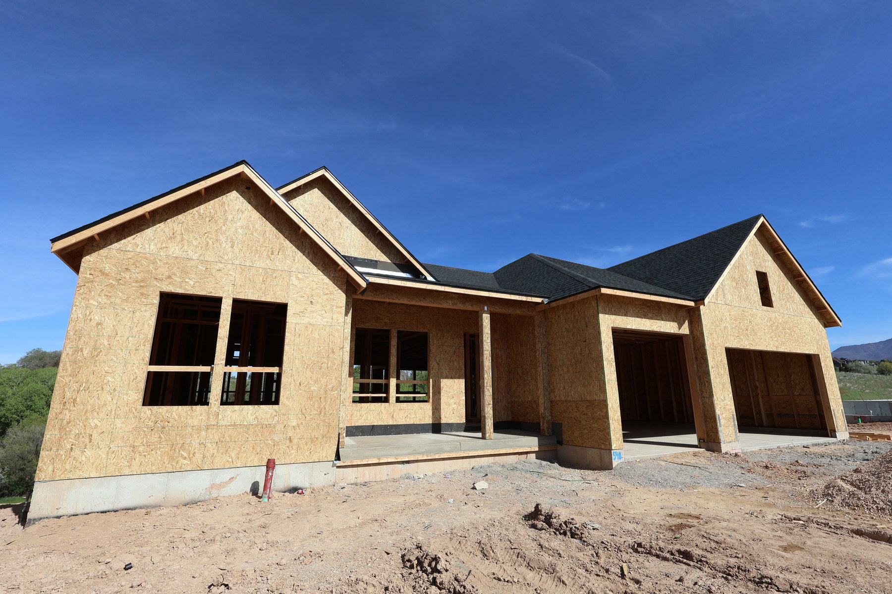 Newly constructed single-story residence with a multi-gabled roofline and attached two-car garage