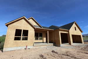 Newly constructed single-story residence with a multi-gabled roofline and attached two-car garage