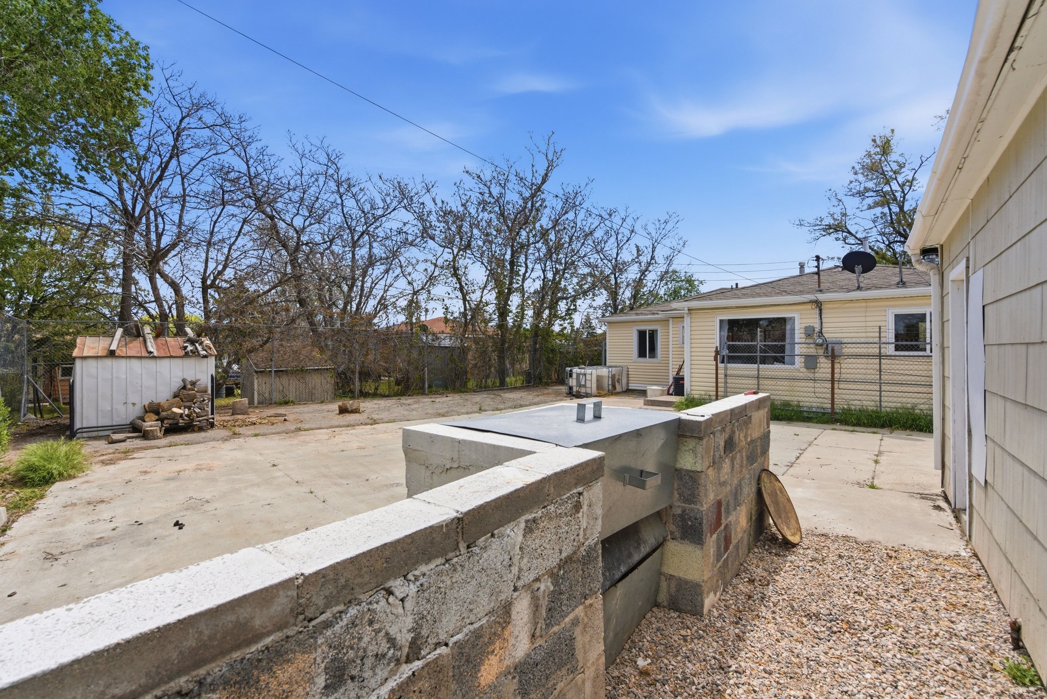 Expansive concrete patio area featuring a built-in outdoor structure with a metal top