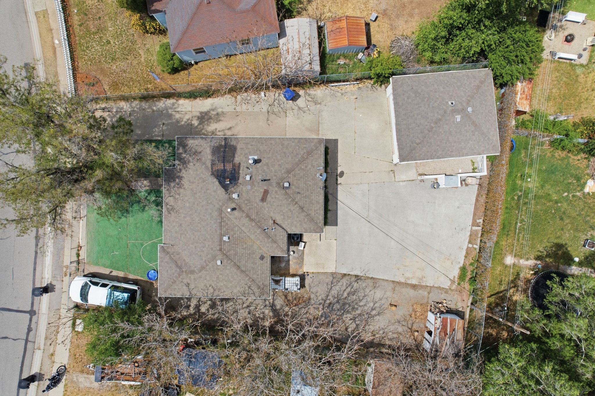 Main residence with a separate accessory dwelling unit, extensive paved areas, and a dedicated green space
