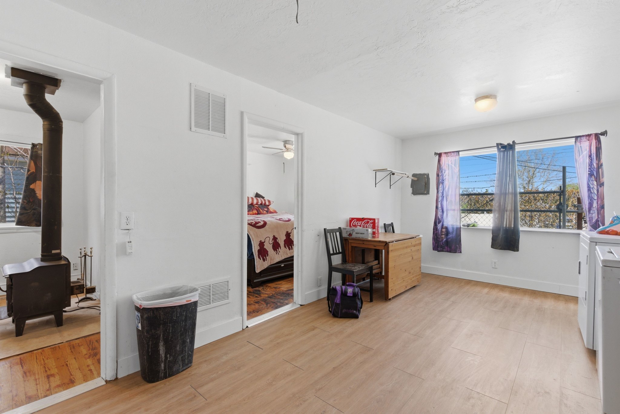 Bright interior space featuring wood-finish flooring, white painted walls, and a flush-mount ceiling light fixture