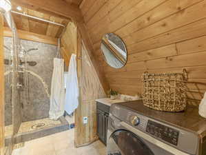 Laundry room with washer / dryer, wood walls, a vaulted wooden ceiling, and light tile patterned flooring