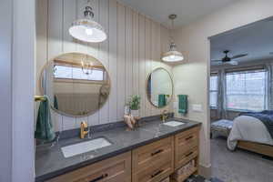 Dual vanity with dark stone countertops, under-mount sinks, and gold-finish faucets
