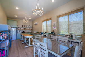 Spacious room featuring wood-finish flooring, recessed lighting, and two elegant chandeliers