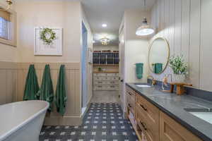Freestanding bathtub with wainscoting and patterned floor tile
