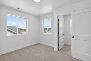 Bright room featuring neutral carpeting, white walls, and two windows providing natural light