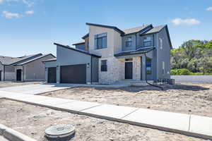 Contemporary multi-level residence featuring a striking stone and siding exterior