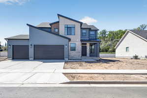 Contemporary exterior featuring multi-toned siding, stone accents, and a distinctive sloped roofline