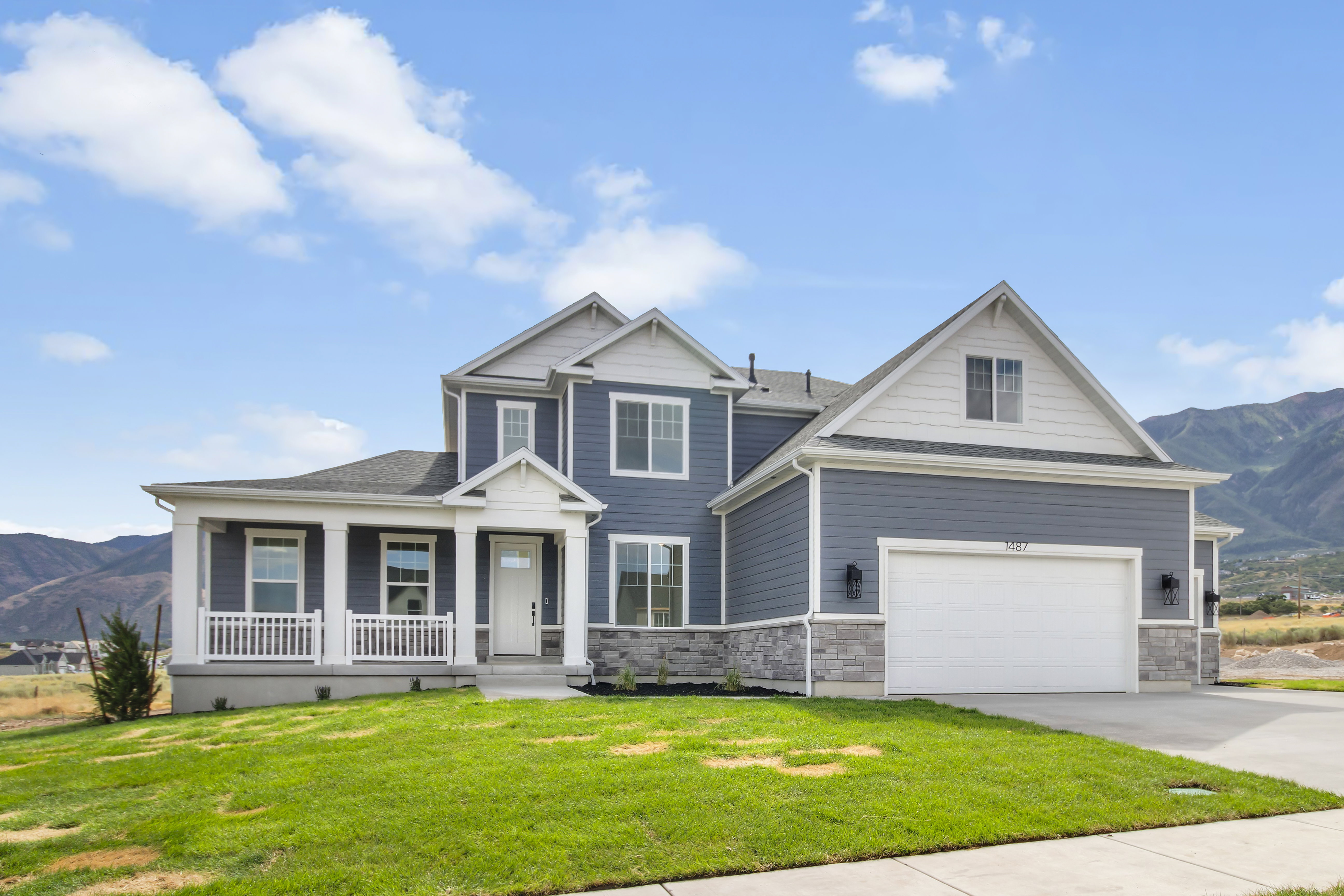 Contemporary two-story residence with a covered front porch featuring white railings