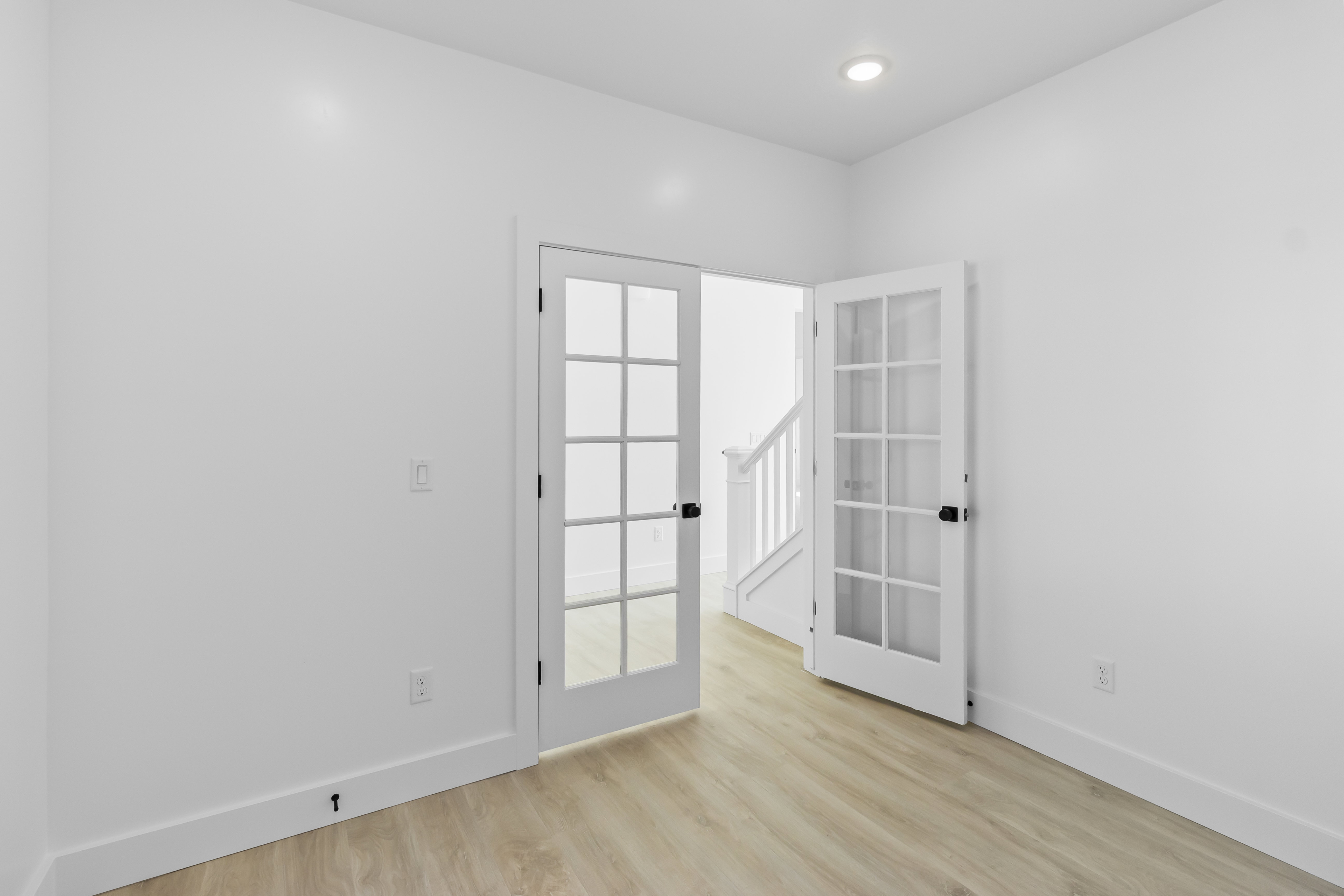Room featuring light wood-finish flooring, white walls, and recessed lighting