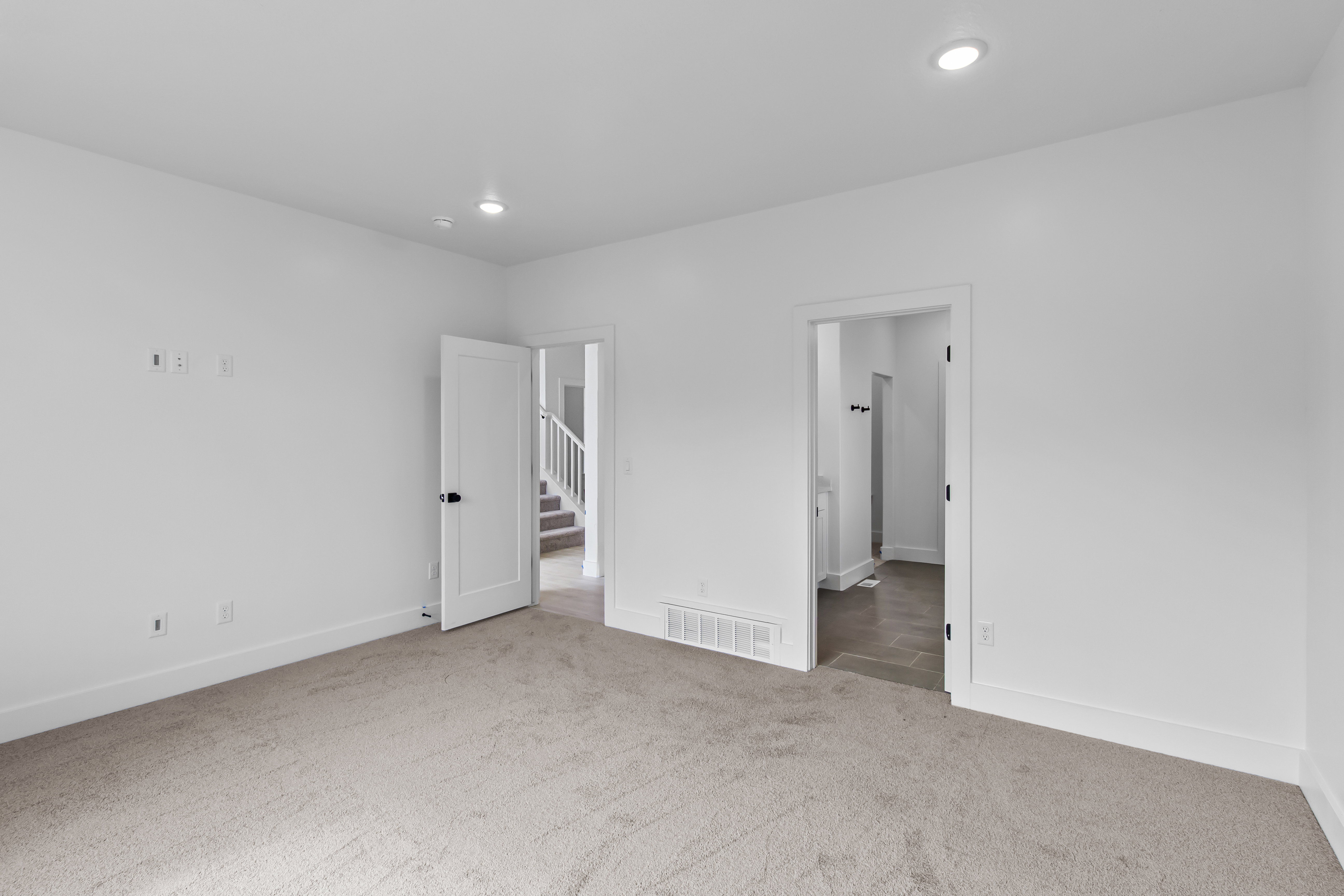 Spacious room featuring neutral carpeting and white painted walls