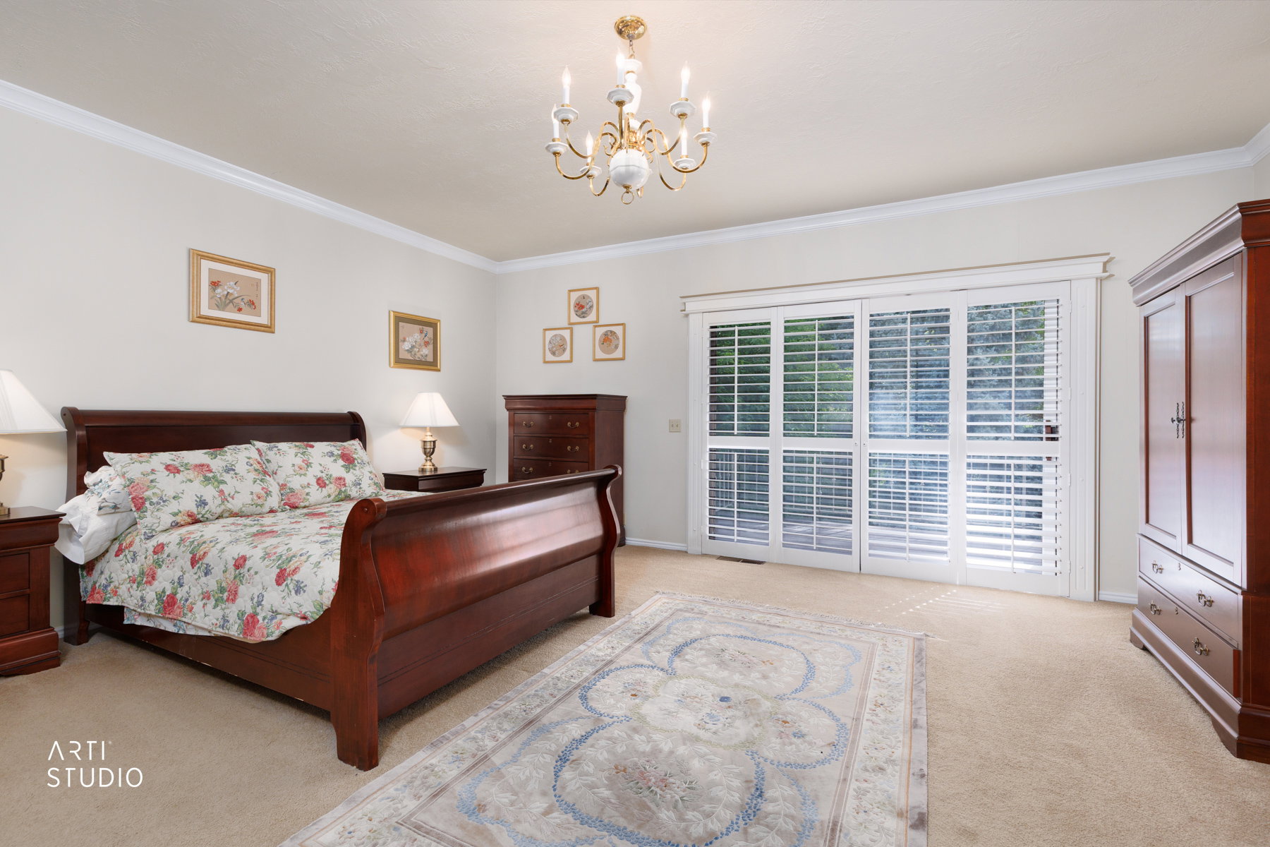 Master bedroom featuring light-colored walls, crown molding, and carpeted flooring