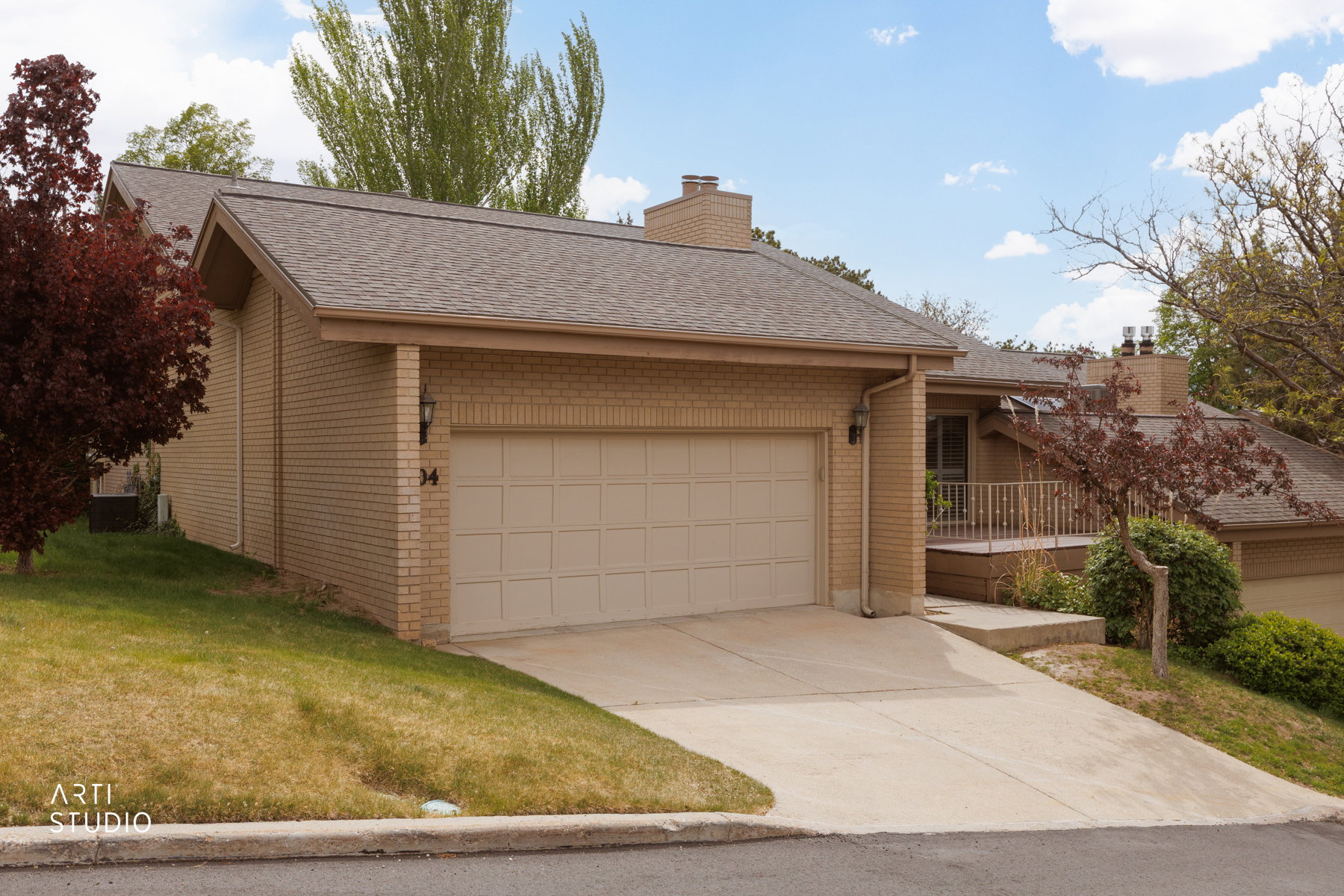 Front of property featuring walk up, front deck, two car garage, and mature landscaping
