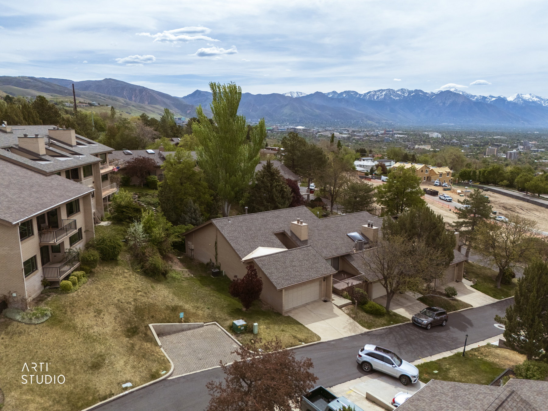 Aerial view of property showing neighborhood and mountain background.