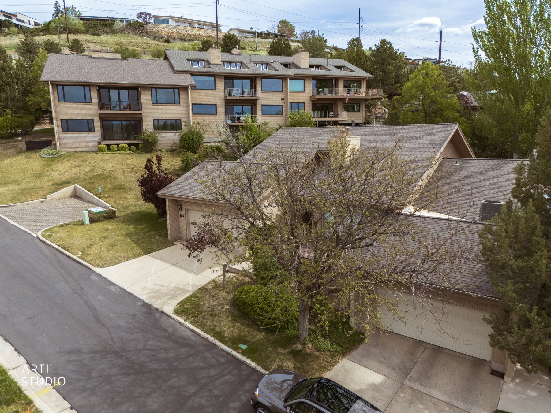View of residence from southwest  featuring a two-car garage, concrete driveway, and a shingled roof