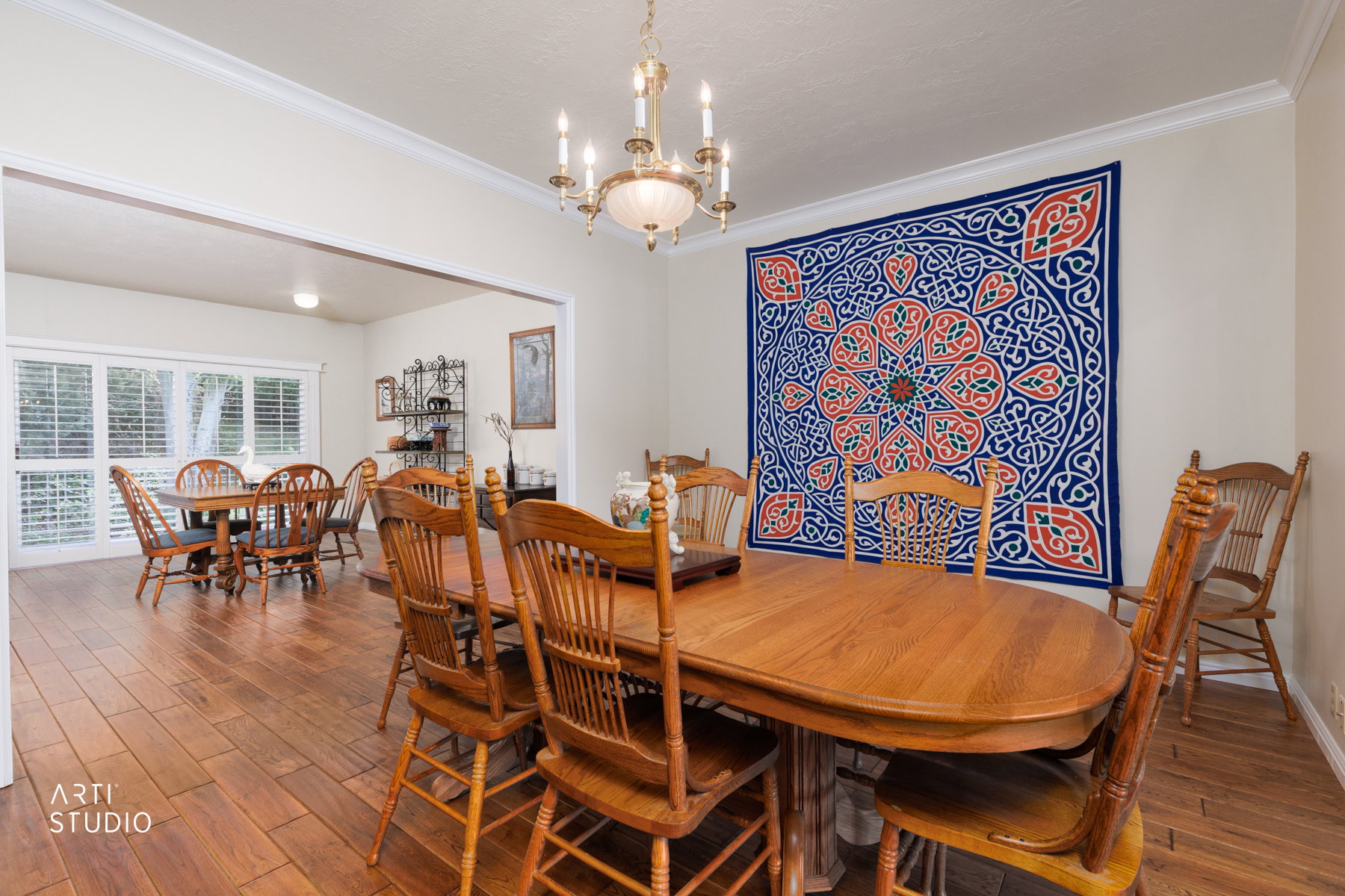 Dining area featuring wood-finish flooring, a chandelier, and crown molding