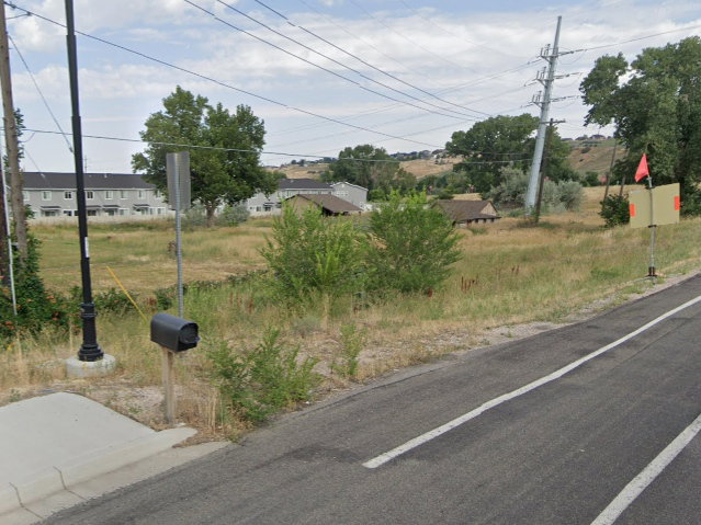 View of asphalt road with a residential view and sidewalks