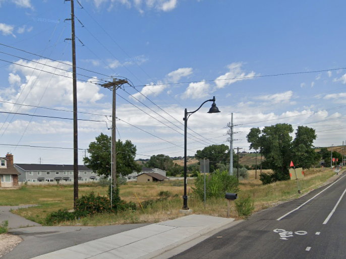 View of asphalt street with a residential view, street lighting, and sidewalks