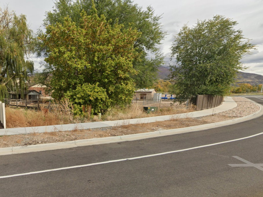 View of asphalt road with sidewalks, curbs, and a mountain view
